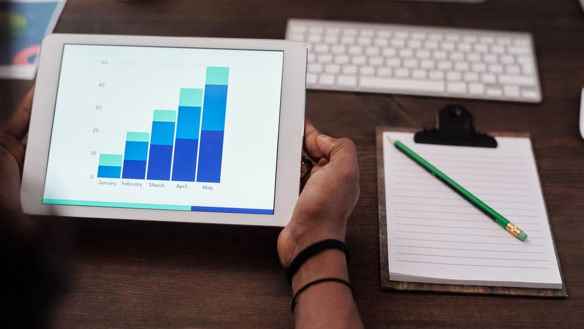 Caregiver reviewing progress charts and behavior data on a tablet with clipboard notes