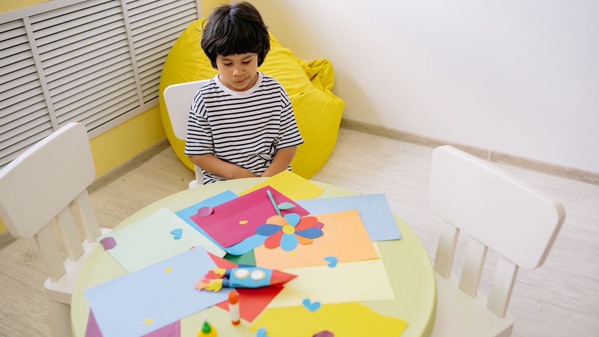 Child practicing structured daily living skills with visual crafts and step-by-step activities at a table