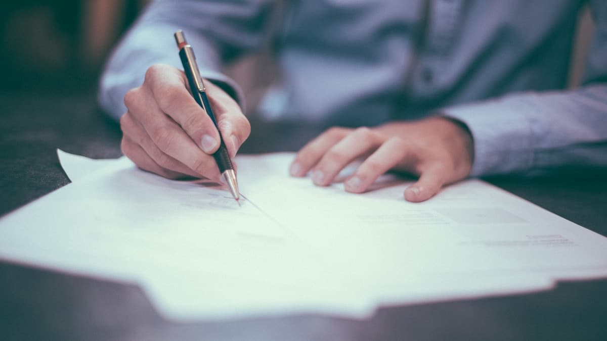 Parent writing in a structured coaching plan and documentation packet at a desk
